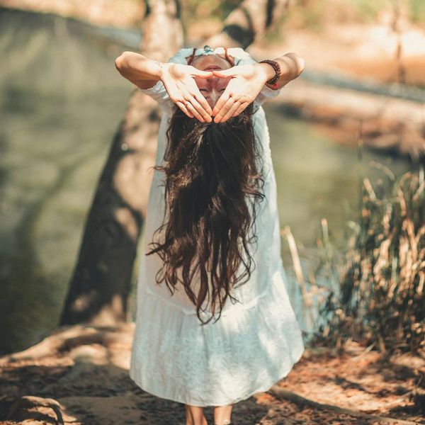 Person meditating peacefully in a bright, natural environment.